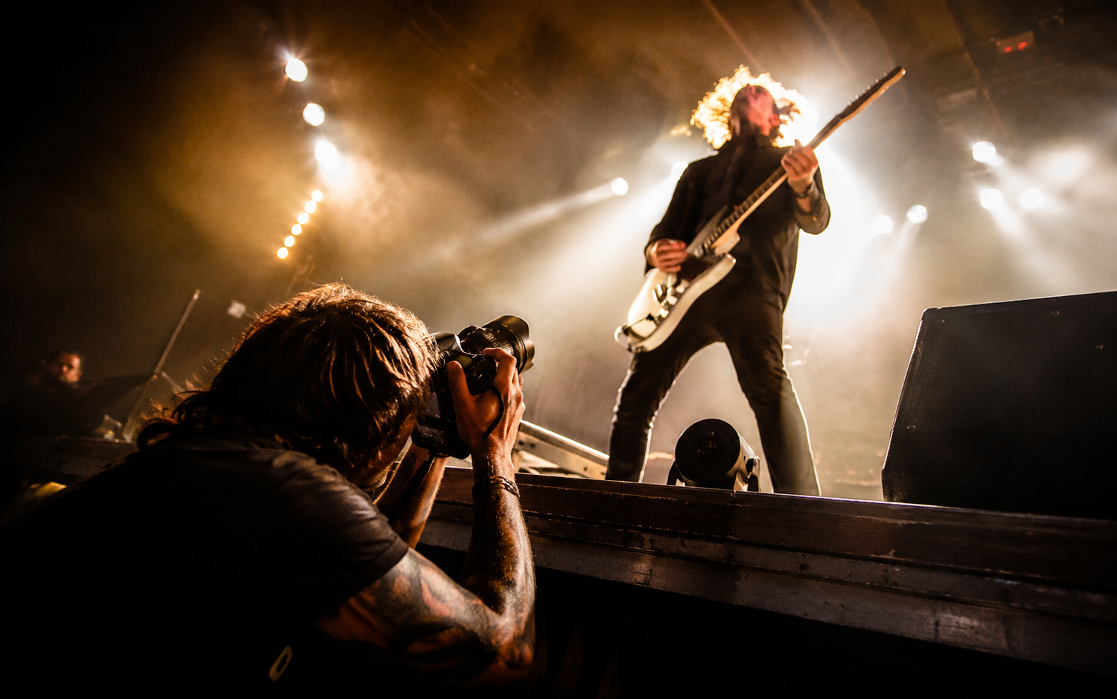 A photographer shooting a band from the pit