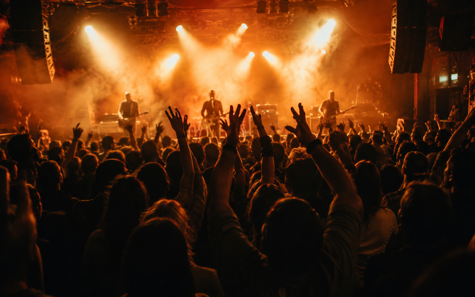 A crowd watching a band perform on a small stage